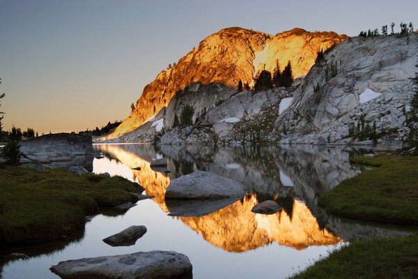 Kontrast. Orange und grau. Die Berge. Der Fluss