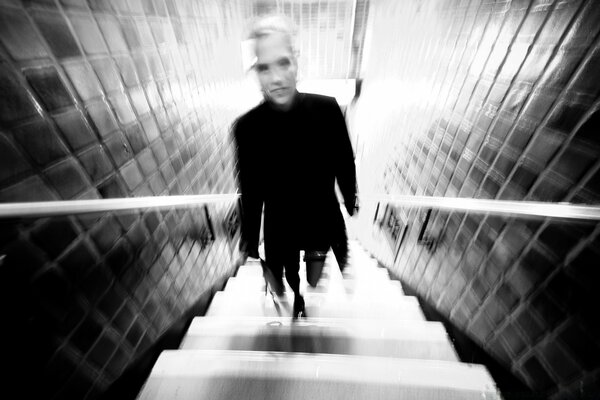 Mann klettert die Treppe hinauf verschwommenes Schwarz und Weiß