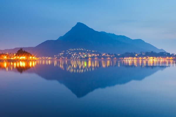 Die Reflexion des Berges und der Lichter der Stadt im Wasser