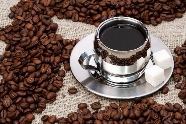 Kaffee mit Zucker unter zerbröselten Kaffeebohnen