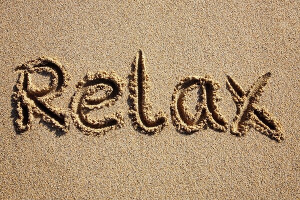 Die Inschrift des Wortes auf dem Sand am Strand des Meeres