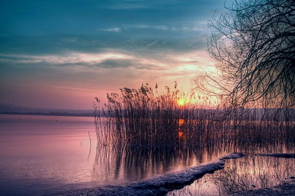 Landschaft. Sonnenuntergang und Sonnenaufgang auf dem Wasser