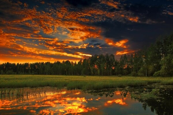 Ein feuriger Sonnenuntergang spiegelt sich in der Wasseroberfläche des Sees wider