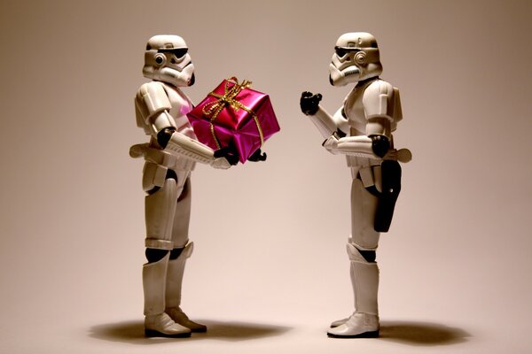 Roboterfiguren aus dem Star Wars-Film mit Geschenk in der Hand