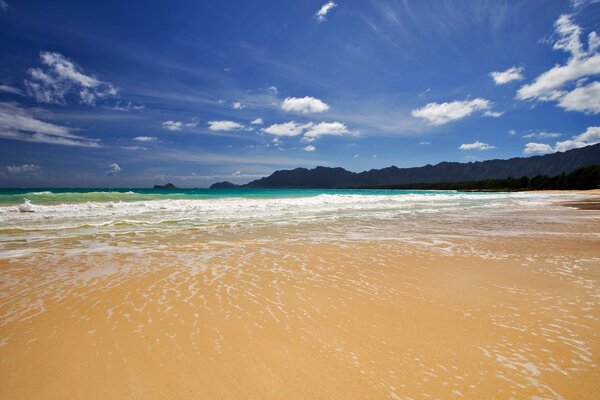 Sandstrand vor dem Hintergrund des blauen Himmels