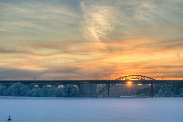 Eisenbahnpfosten auf Sonnenuntergang Hintergrund. Winterlandschaft